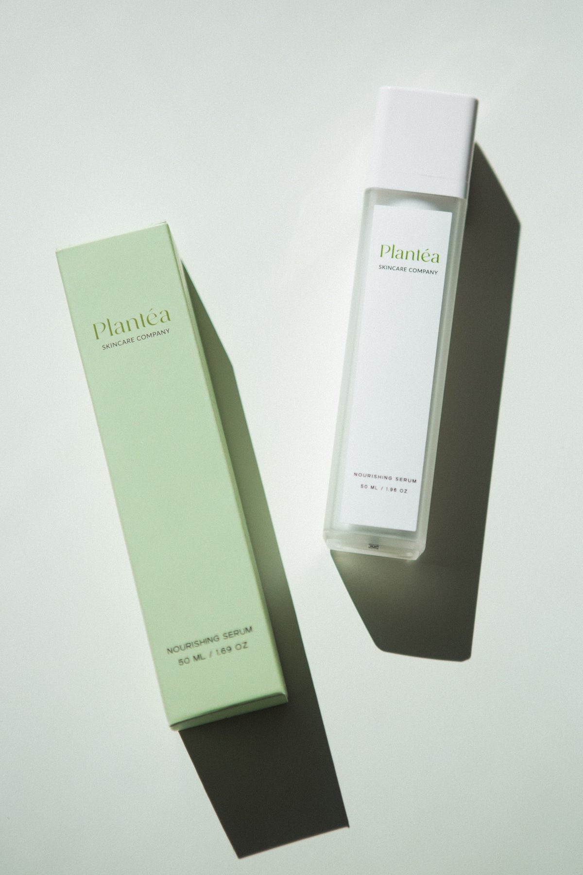 flatlay image of Plantéa Nourishing Serum bottle with its green box next to it