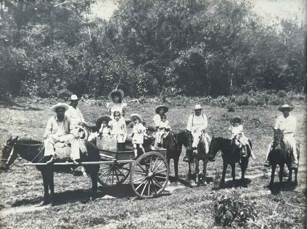 Vintage photo of people riding horses and a cart in a rural setting