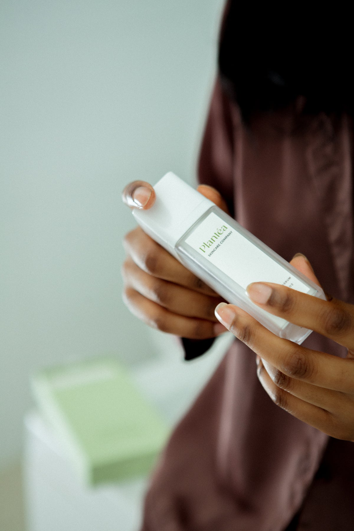 woman's hands holding Plantéa Nourishing Serum; close up image