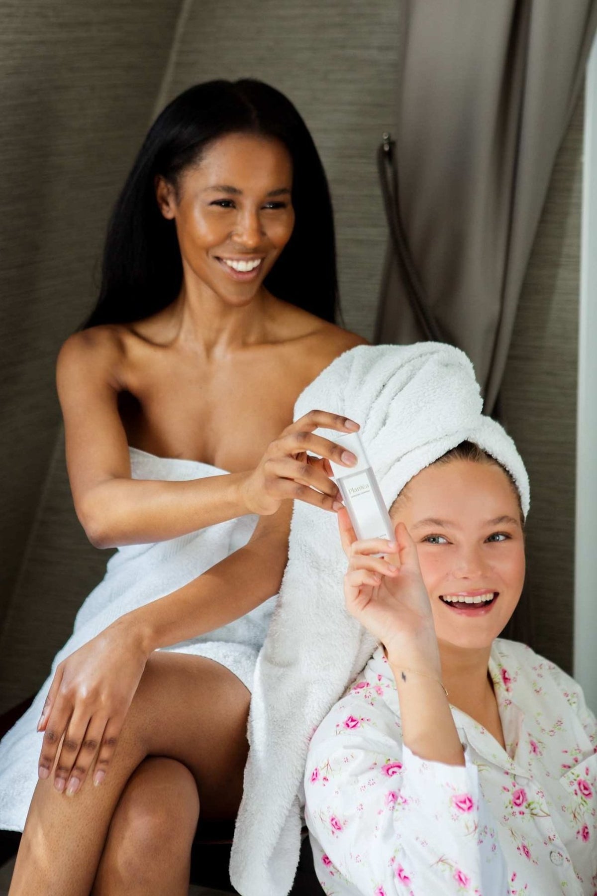 Two women passing Plantéa's Nourishing Serum to each other.