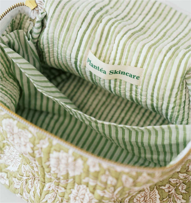 Open green and white striped bag with a "Plantea Skincare" label, featuring floral design on the exterior.
